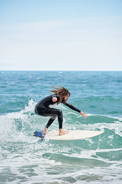 istock Surfboarder with long hair riding a wave 2189200006