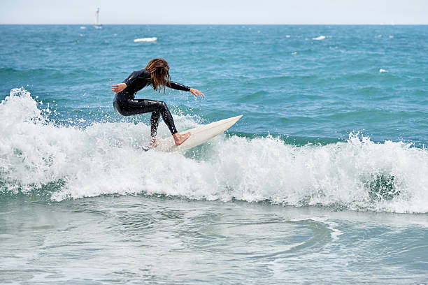 istock Long-haired bearded surfer on board riding waves 2189200044