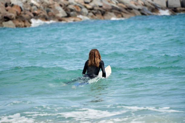 istock Surfer in wetsuit on surfboard in water 2189200159