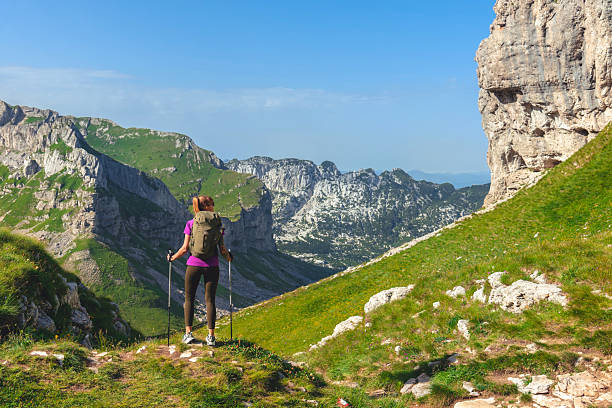 istock Woman with Hiking Poles Walking in Alps Mountains 2189201737