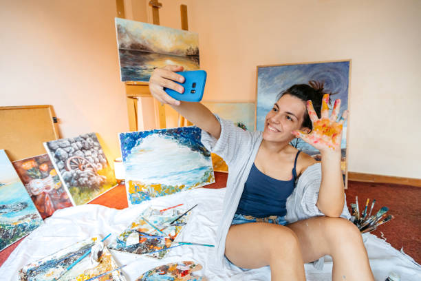istock Young Female Artist Taking Selfies While Panting On The Floor At Home 2189202210
