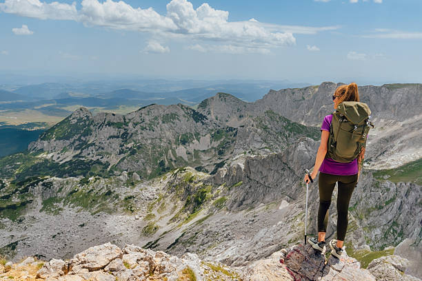 istock Woman Standing Backwards on Rocky Mountain Peak 2189202274