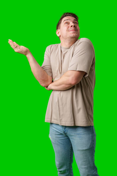 istock A person smiling and gesturing with hands in front of a bright green backdrop 2189204754