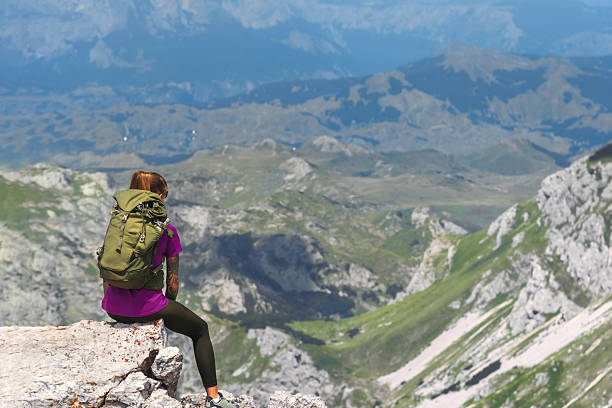 istock Woman Sitting on Mountain Summit Cliff after Climbing 2189206084