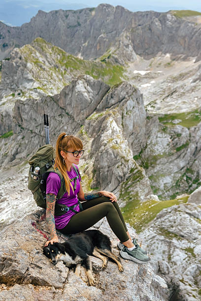 istock Female Hiker with Dog Sitting on Mountain Top 2189206655