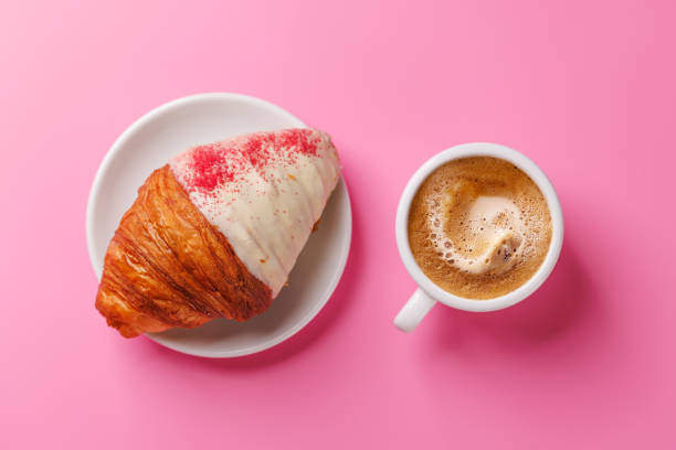 A delightful pairing of a freshly brewed coffee and a raspberry croissant
