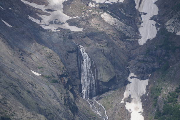 The waterfall is located in the mountains. Natural background.