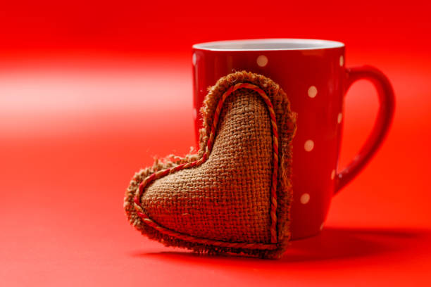 A delightful combination of a steaming coffee cup and a heart-shaped gift, ideal for Valentine's Day moments or romantic gestures