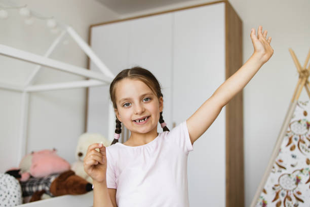 istock Joyful little girl with missing tooth celebrating at home 2189209831