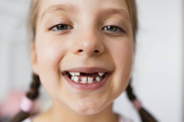 istock Smiling little girl with missing baby teeth at home 2189209838