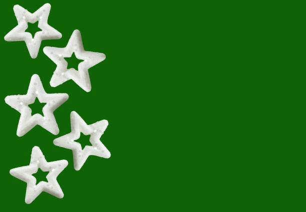 Christmas decorations isolated on green background with copy space. New Year stars. White stars with glitters, design element, red background. Isolated white stars, xmas decor