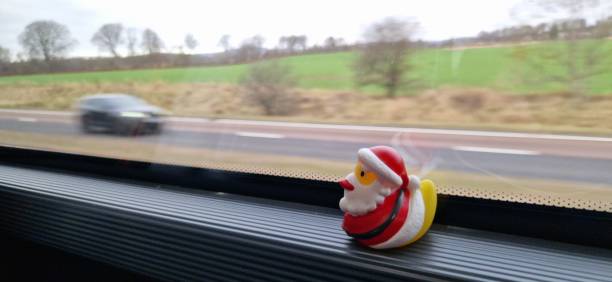 Santa duck on window ledge of bus in countryside