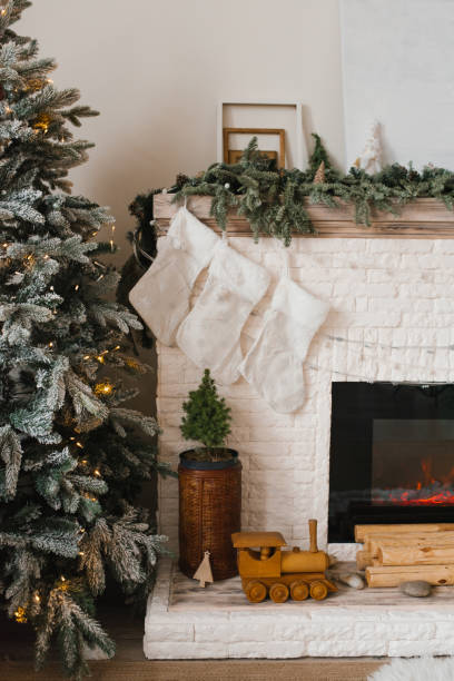 istock White fireplace mantel with a Christmas tree and stockings hanging from it 2189215456