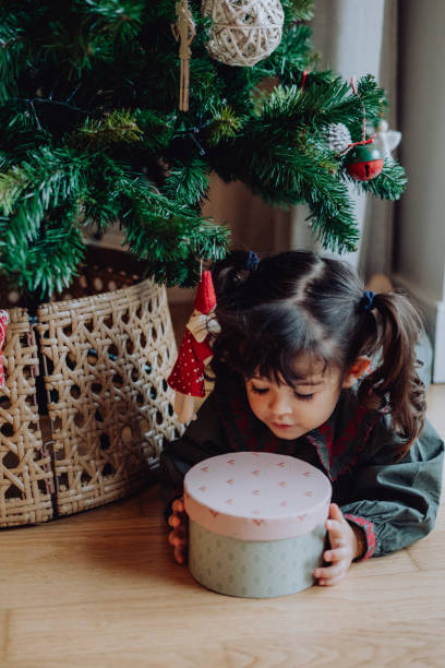 istock Happy girl enjoying her Christmas present under the tree 2189217967
