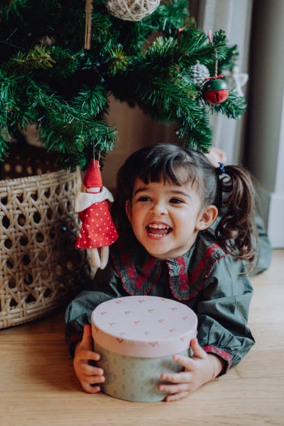 istock Happy girl enjoying her Christmas present under the tree 2189217985