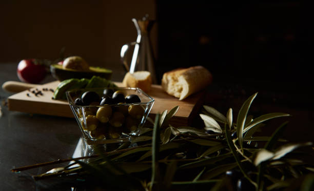istock Rustic Mediterranean olives and baguette on a wooden kitchen counter 2189218839