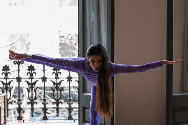 istock Woman stretching legs while practicing yoga at home 2189220539