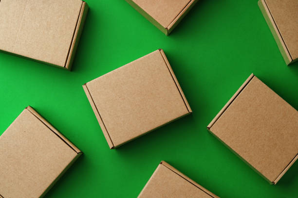istock Brown cardboard boxes arranged on a vibrant green surface 2189221862