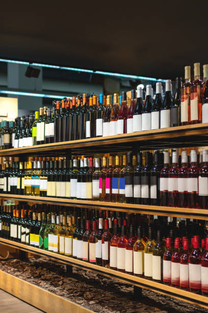 istock Vertical background of wine bottles displayed on shelves in a liquor store. 2189221977
