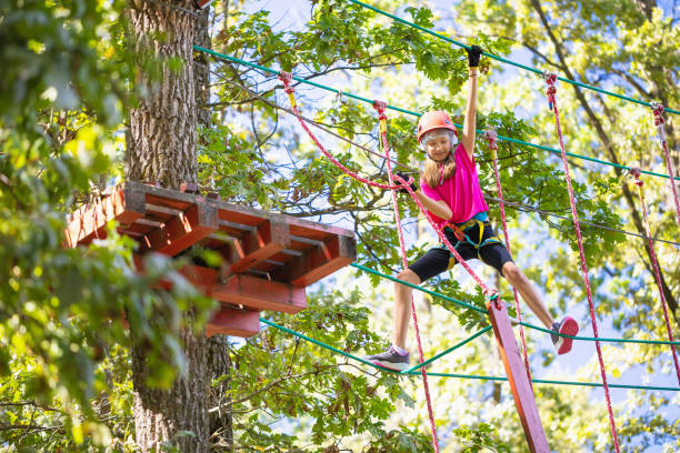 istock Child goes through rope obstacle course, takes out crossbar to move forward, doing extreme sports in amusement park 2189222948