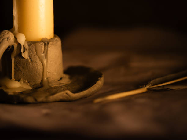 istock Writing quill on parchment by candlelight 2189224446
