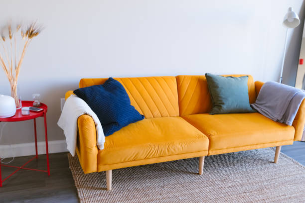 istock bright orange sofa with contrasting cushions, paired with a red side table and minimal decor 2189224481