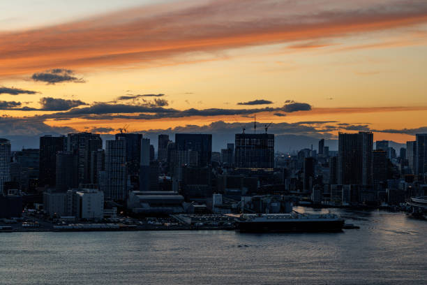 Sunset over the big city. Skyline at sunset, brilliantly reflecting vibrant colors on the water below