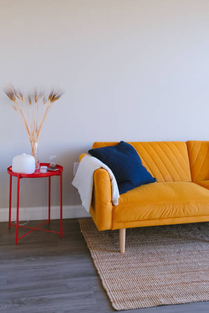 istock cozy living room design setup featuring a bright orange sofa with cushions, a red side table, and minimal decor 2189225345