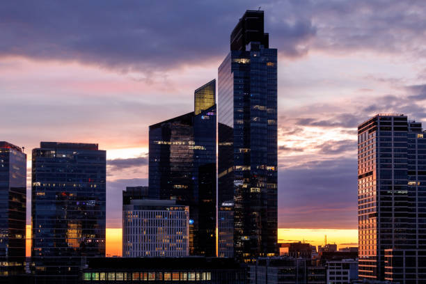 A cityscape with modern architecture under a beautifully colorful dusk sky.