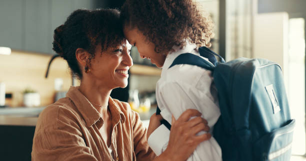 istock Mother, girl and uniform with forehead touch in home for preparing or ready for elementary education. Apartment, people and parent with kid for back to school with smile, pride or child development 2189228433