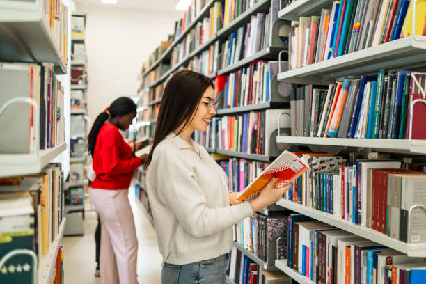 istock Female student holding book at library 2189228893