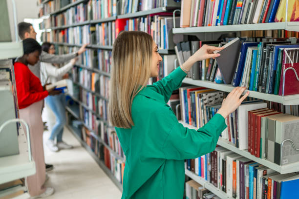 istock Young female student choosing a book in the library 2189229206