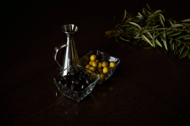 istock Olive branches with black and green olives on wooden table 2189230745