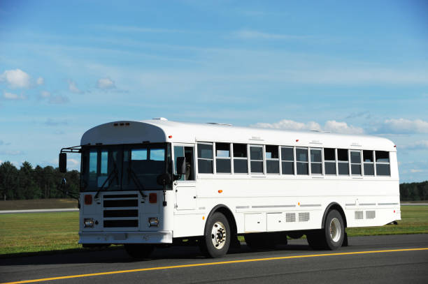 white school bus driving on the road