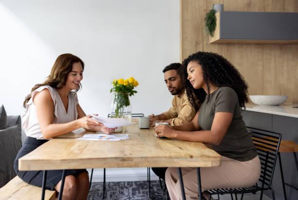 istock Happy financial advisor showing documents to a couple at home 2189234816
