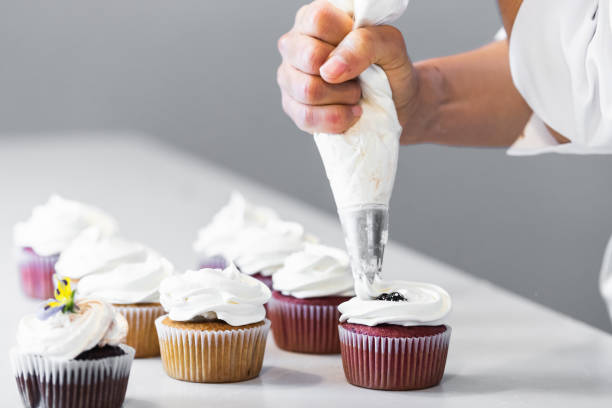 istock Crop cook decorating cupcakes with whipped cream 2189239337