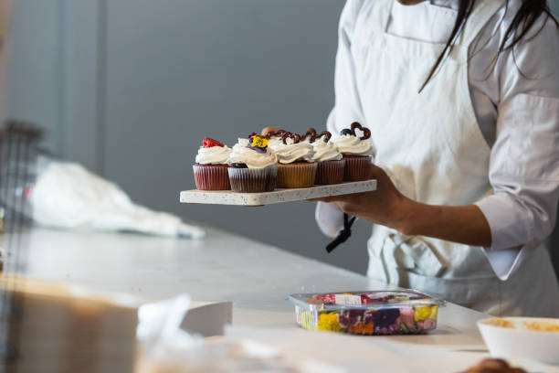 istock Crop baker with sweet cupcakes in kitchen 2189239359