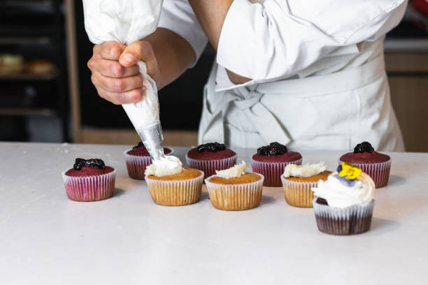 istock Crop cook decorating cupcakes with whipped cream 2189239487