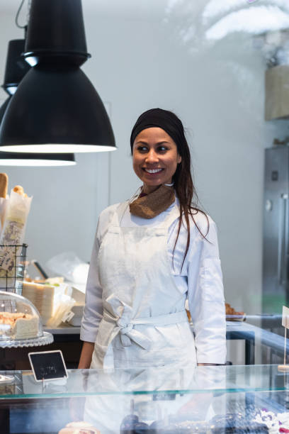 istock Cheerful woman standing at counter in bakery 2189239497