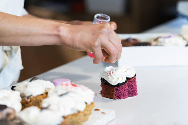 istock Crop baker decorating velvet cake with cream 2189239746