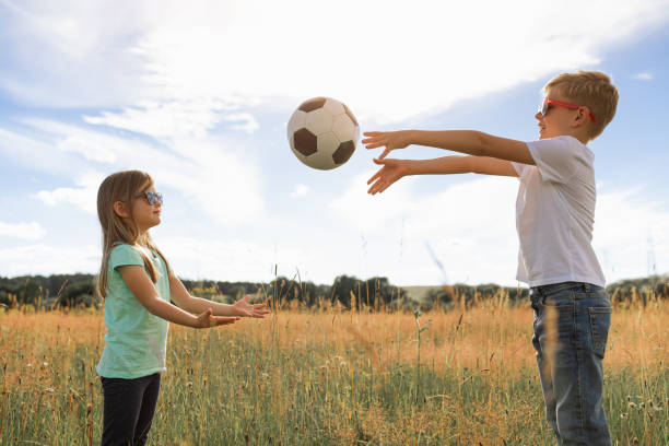 istock Kids playing with ball in the field. 2189246051
