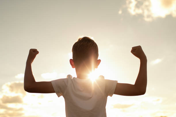 Strong healthy active confident boy flexing his muscles and feeling like a winner.