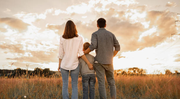 istock Happy family watching the sunset in the meadow. 2189246693