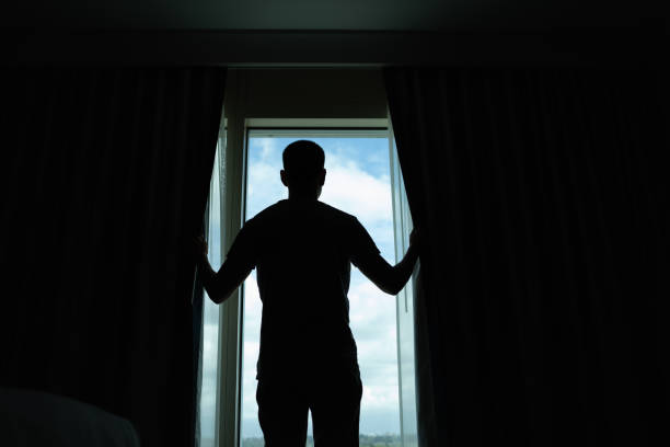 istock Man opening curtains and letting light in the room. 2189246707