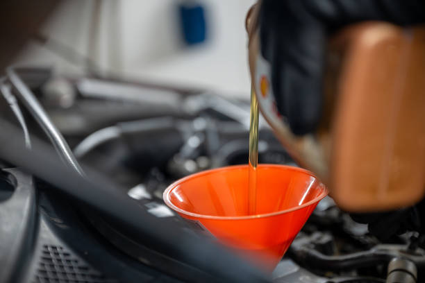 istock Mechanic pouring oil into a car engine using a funnel 2189248296