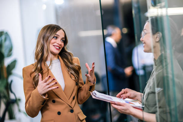 istock Two businesswoman colleagues talking and smiling in their office. 2189249861