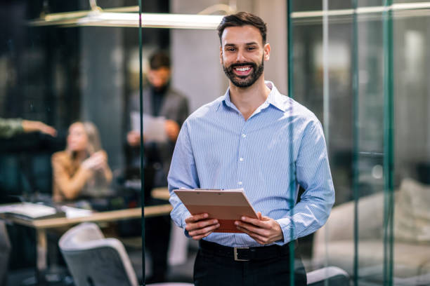 istock Man business CEO standing in his office with paperwork. 2189254336