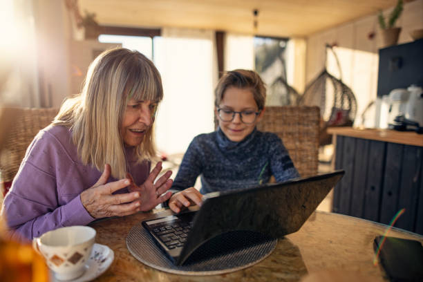 istock Boy setting up a laptop for his grandmother 2189254494