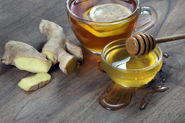 istock honey, a cup of tea with lemon and ginger on a wooden table 2189254611