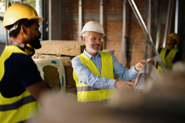 istock Team of Construction Workers Reviewing Blueprints on Site 2189260227
